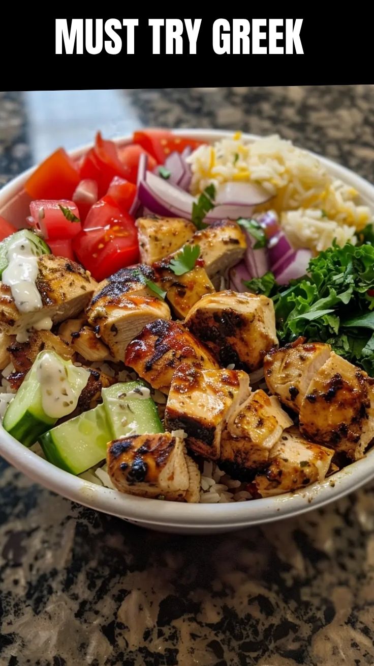 A vibrant Greek chicken bowl with fresh vegetables and feta cheese