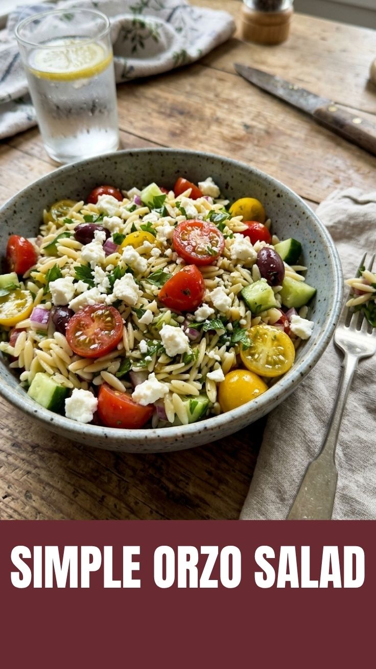A colorful summer orzo salad with fresh vegetables and herbs in a bowl.