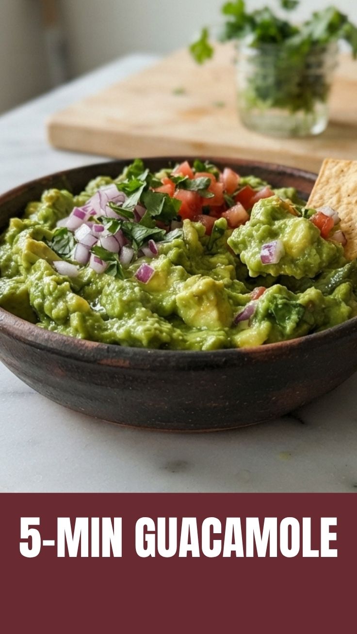 A bowl of freshly made guacamole with vibrant green avocado, red tomatoes, and cilantro