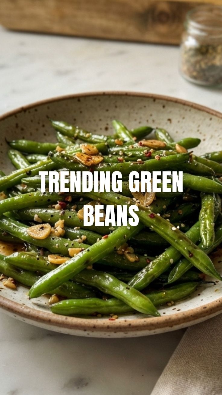 Vibrant green beans tossed with minced garlic and herbs in a serving dish.
